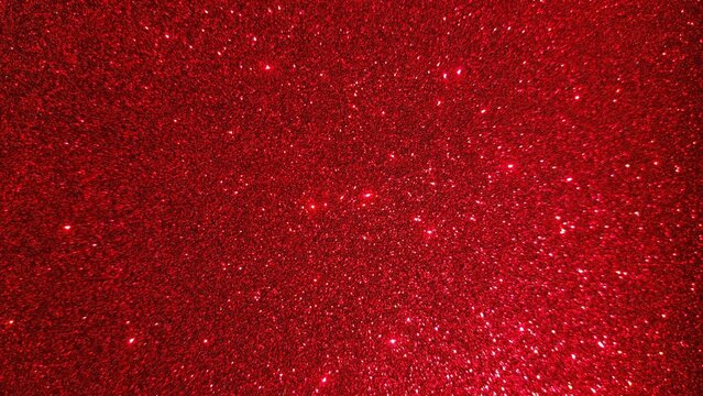 Beautiful abstract red glitter background featuring bright glowing particles. Luxury red shimmer texture with an elegant festive glow effect.