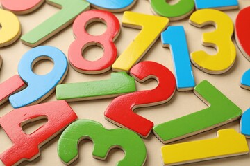 Fototapeta premium Different colorful numbers on beige background, closeup