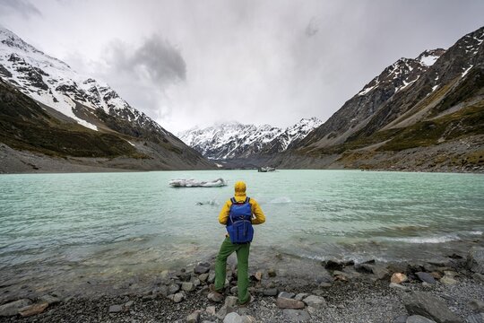 Hiker views Hooker Lake in Hooker Valley, Mount Cook National Park, Southern Alps, Hooker Valley, Canterbury, South Island