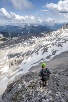 Hikers on the Hermann von Barth trail, via ferrata to the Partenkirchner Dreitorspitze, view of the Leutascher Platt, Karwendel Mountains in the background, Wetterstein Mountains, Bavaria, Germany