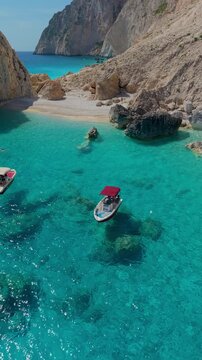 Immerse yourself in the stunning turquoise waters of Myzithres Beach, Keri, Zakynthos. Enjoy sun-soaked moments as boats glide through the tranquil sea, revealing the beauty of this hidden gem.