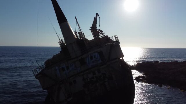 Close-up aerial view of the rusty Edro III shipwreck with the Peyia coastline in the background