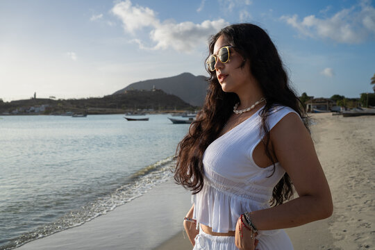 El sol del atardecer en la Isla de Margarita est&aacute; abrazando el rostro de la bella dama que lleva un bonito conjunto blanco.