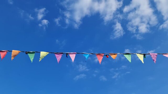 Colorful pennant flags waving in the wind against a blue sky
