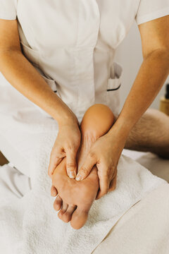 Close up of foot massage therapy session. Female massage therapist's hands.