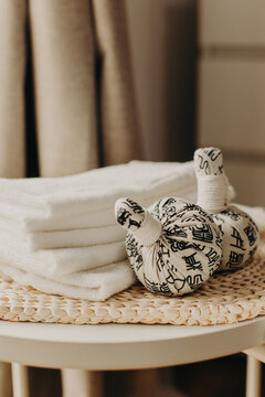 Minimalist still life of luxury spa essentials. White cotton towels with visible textured on a table.