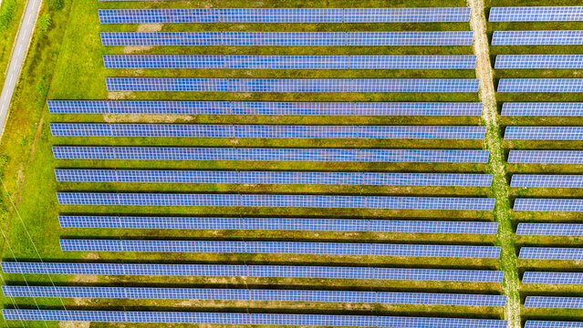 Aerial view of rows of solar panels in a field in Auvergne-Rhone-Alpes, France.