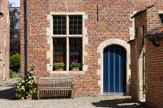 Quiet cobblestone courtyard at the Great Beguinage (Begijnhof), Leuven, Belgium, historic brick houses and bench