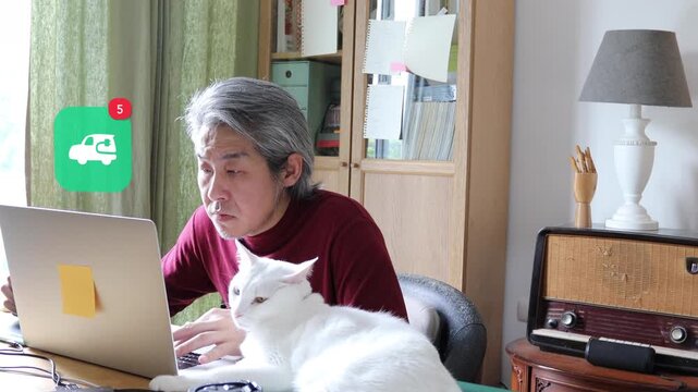 White haired mature Asian man using laptop at home with his cat, featuring a 3D tracked electric vehicle plug eco smart city car notification pop up and red counter.