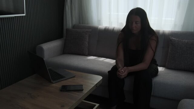 Young woman struggling with work motivation while looking at laptop at home, procrastination, burnout and productivity challenges concept