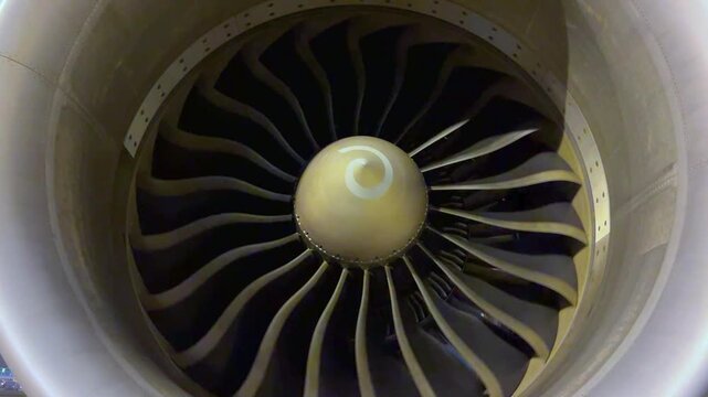 Front macro shot of airplane jet engine compressor blades turning slowly technical maintenance and inspection concept commercial aircraft propulsion clip