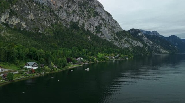 Aerial view of Traunsee lake shoreline below steep mountain cliffs, Austria