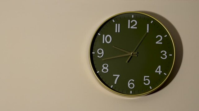 Static shot of a modern green wall clock, frozen time and patience concept with copy space.