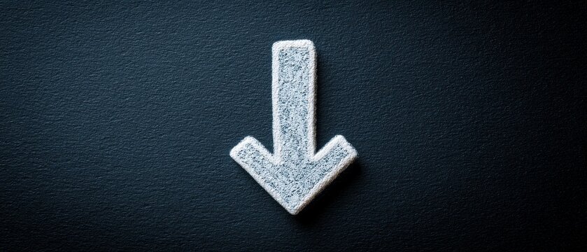 Close-up of white downward arrow on dark textured background, symbolizing decline or decrease