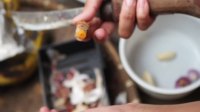 Close-up of Hands Peeling Fresh Turmeric Root with a Knife for Cooking