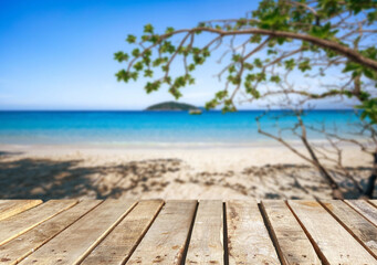 Fototapeta premium Wooden table top on the beach or sea.Party on the beach sunshine time concept.For montage product display or design key visual layout.View of copy space.