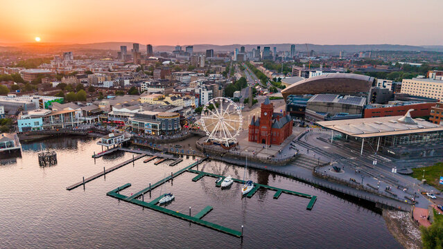 Aerial view of Cardiff Bay waterfront at dusk featuring the Pierhead Building and Ferris wheel.