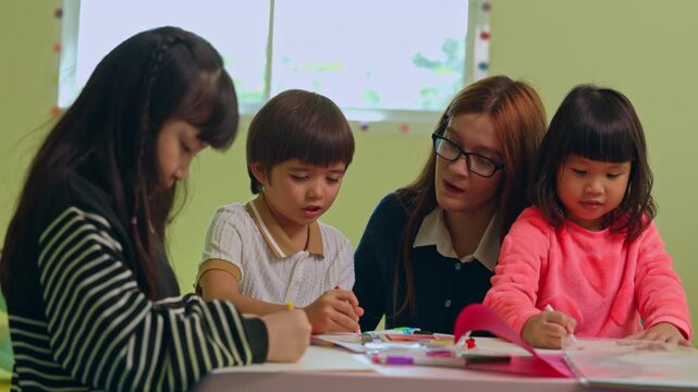 Happy teacher guides focused child and student group inside colorful classroom during creative drawing and writing session promoting active early childhood education and joyful learning