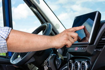 Naklejka premium Hand touching digital screen on vehicle dashboard
