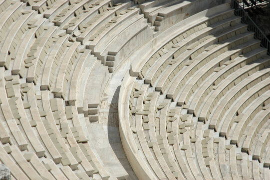 A high angle detailed view of the restored white marble seating rows in the ancient amphitheater of the Odeon of Herodes Atticus in Athens Greece.