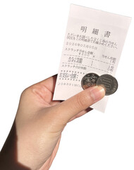 Hand holding a Japanese receipt with coins, close-up of payment transaction, shopping expense, cash...