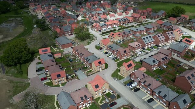 This aerial view shows new homes built by Barratt Homes in Boroughbridge, UK. The area features streets lined with houses and green spaces. The development highlights modern living options