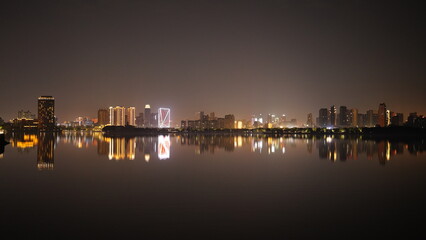 Fototapeta premium The night city view with the reflection in water at night