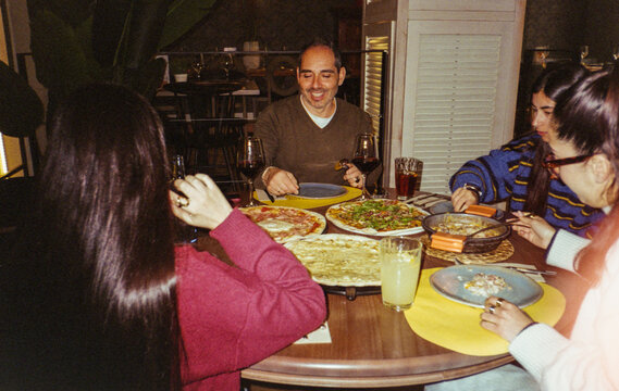 Happy diverse group of friends sharing pizza at a restaurant