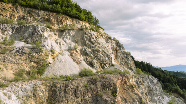 Aerial view of the Kamnolom Plese pri Skofljici quarry showing exposed rock faces, gravel slopes, and surrounding forest in Mali Vrh pri Smarju, Grosuplje, Slovenia.