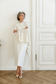 Elegant Mature Woman Standing in Minimalist Interior