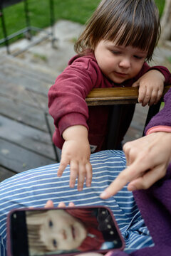 Child Reaches out to Smartphone Screen During Outdoor Activity