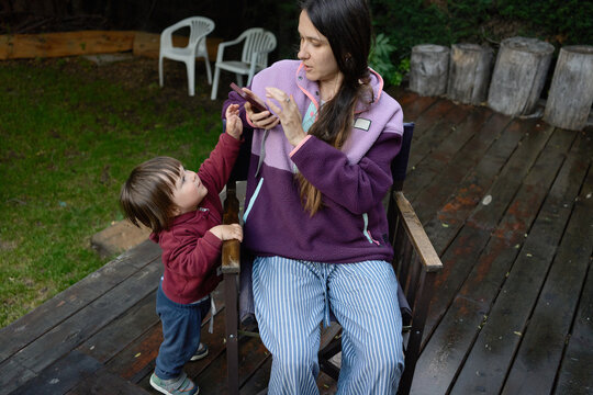 Woman Interacts With Child on Outdoor Deck in a Backyard Setting