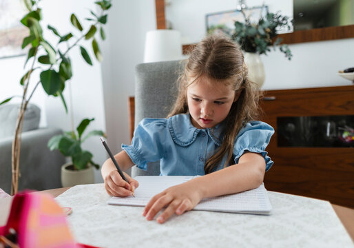 Young girl learning writing doing homework at home