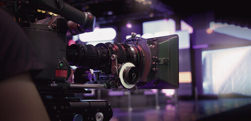 Behind the scenes of movie shooting or video production at studio with high quality camera gimbal or tripod equipment set up and professional film crew team or camera operator with flare lighting. © gnepphoto