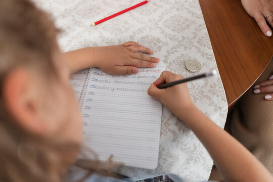 Child's hands writing in notebook, learning calligraphy skills