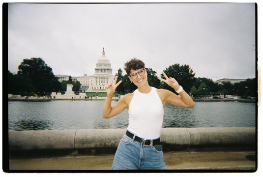 Woman making peace sign near US Capitol Building in Washington