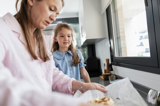 Mother and daughter baking, preparing food together in kitchen