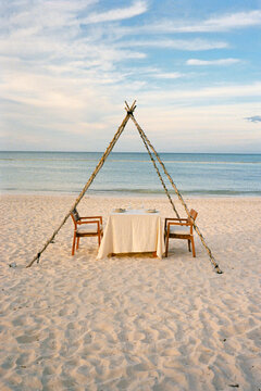 A setting for a couple's dinner on the beach by the sea