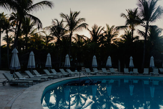 Sunset at a Punta Cana resort pool with lounge chairs and palms