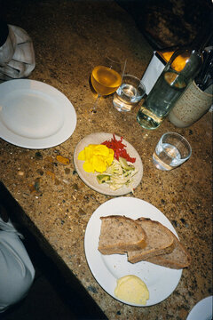 A stone table with a salad, sourdough bread, and wine