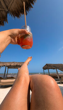 Woman Relaxing on Tropical Beach Holding Fresh Fruit Cocktail