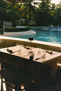 Table set for dinner at a restaurant next to a resort pool