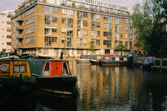 Film-style wide scene captures London canals with boats lit by sun
