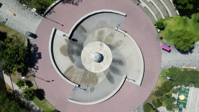 Zapopan, Mexico - March 21 2026: Top down drone video reveals the intricate spiral design of the central fountain in Children and Girls Park, Zapopan. Shows urban green space and recreation areas.