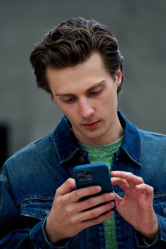 Young Man Using Smartphone in Urban Space at Daytime