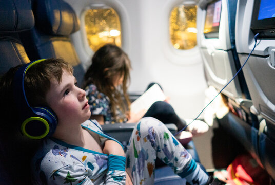 Family traveling on airplane watching in-flight entertainment