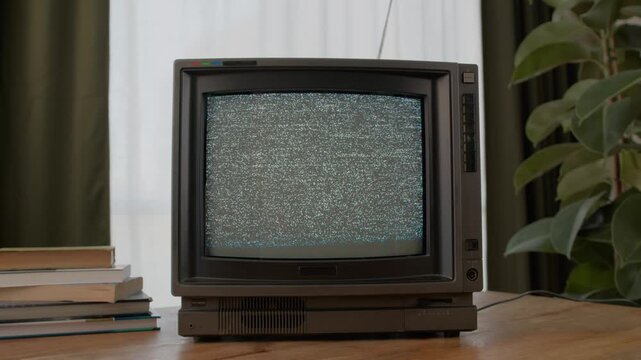 Retro TV, vintage television In a nostalgic setup, a retro TV displays grain on screen, scary halloween night device good for chroma key and green screen.