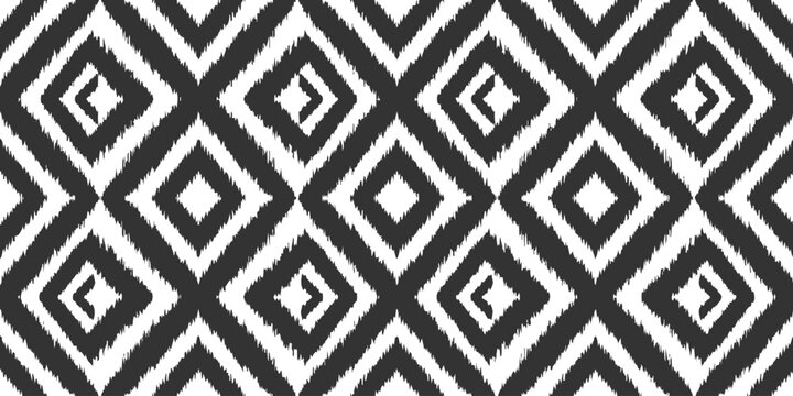 Seamless monochrome ikat pattern with repeating diamond shapes in black and white for textile fabric design