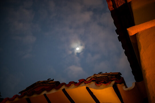 The moon rising over a roof in the Sacred Valley near Cusco in Peru.