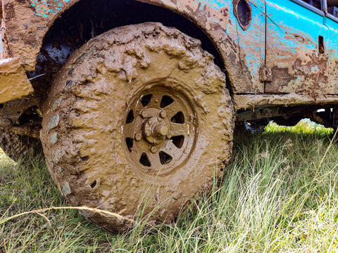 Mud-covered off-road vehicle wheel after crossing an extreme muddy track, highlighting rugged adventure driving, challenging terrain conditions, and the demanding nature of off-road activities.